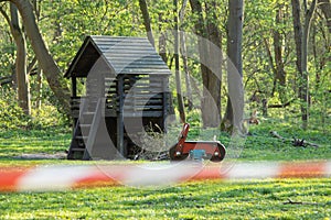 cordoned off playground, surroundet by trees, forcus on background, blurred barrier tape photo
