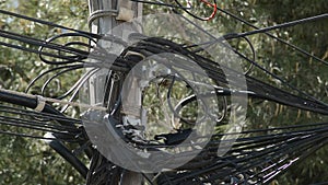 Cords wire of electricity and telephony badly installed on a wooden pole