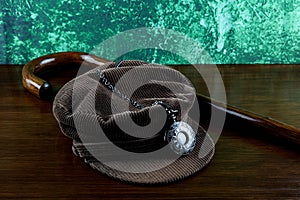 Corduroy Hat with Walking Stick and Pocket Watch on a Varnished Table Top