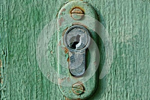 core in an old keyhole on a green wooden door