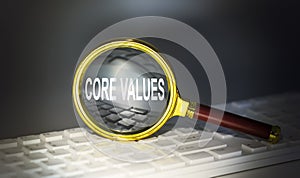CORE VALUES word concept on a magnifier on the keyboard
