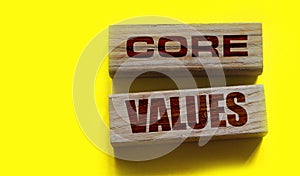 Core values words on wooden blocks on yellow background. Business ethics concept