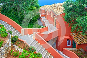 CORFU ISLAND, GREECE, JUNE 03, 2014: Cascade red dark rose white colors hotel. Greek open stone diagonal stair staircase. Cascade