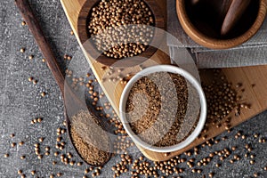 Coriander powder and coriander beans in a wooden spoon. Dry coriander. Coriander seed spice.