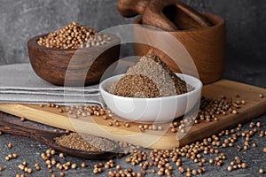 Coriander powder and coriander beans in a wooden spoon. Dry coriander. Coriander seed spice