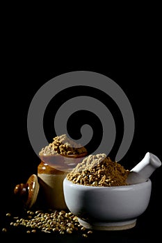 Coriander Powder and Coriander seeds on black background