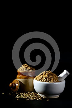 Coriander Powder and Coriander seeds on black background