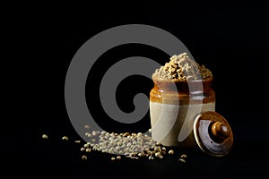 Coriander Powder and seeds on black background.