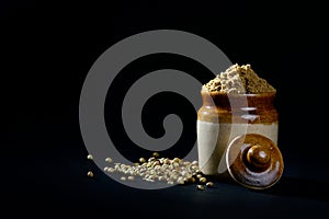 Coriander Powder and seeds on black background.