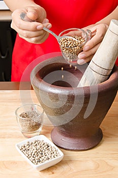 Coriander seed pounding in mortar