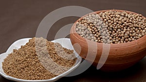 Coriander seeds in a clay bawl, and powder.