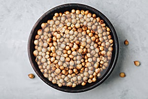 Coriander seeds. Coriander dry seeds in wooden bowl in gray stone background