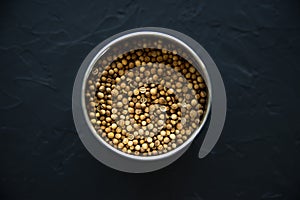 coriander seeds spice in a metal box on a black background