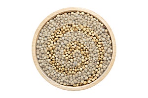 Coriander seeds in wooden bowl isolated top view on white