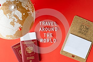 Cork globe with red pins, blank mockup calendar and passports with ticket and text `Travel around the world`