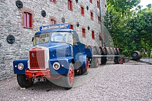 Loading wooden barrels on old open truck trailer in museum