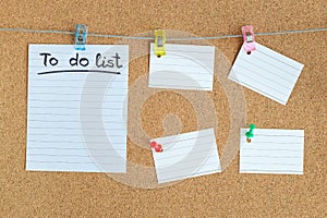 Cork memory board with blank peaces of paper hanging on rope with clothes pin and pinned on board, horizontal