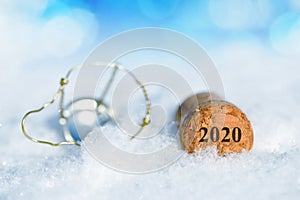 Cork stopper of champagne with number 2020 in snow.