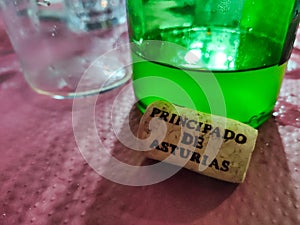 A cork with the text Principado de Asturias and a cider bottle in background, Llanes, Asturias, Spain photo