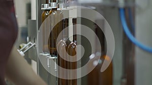 Corking brown glass wine bottles on a conveyor