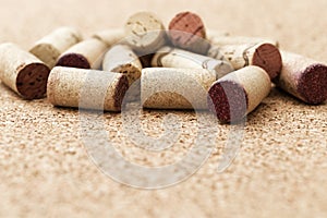 Corks from wine bottles lie in a pile on a wooden cork background. Natural wood fon with heap of corks