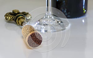 Corkscrew by the bottle and glass of red wine