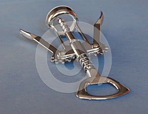 corkscrew and bottle opener over blue