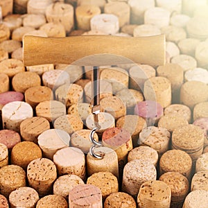 Corkscrew with a wooden handle against the background of wine bottle corks