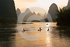 Cormorant fishermen on bamboo rafts in river, China