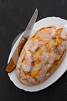 Corn bread with knife on white dish