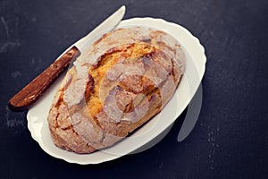 Corn bread with knife on white dish