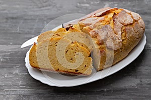 Corn bread with knife on white dish
