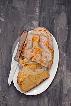 Corn bread with knife on white dish