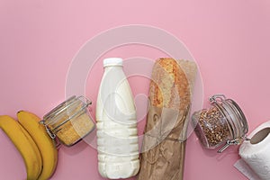 Corn, buckwheat, bananas, milk, bread in white bag on blue background photo
