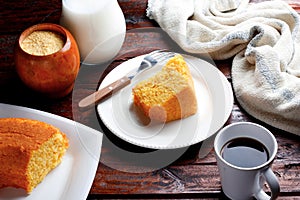 Corn Cake With Coconut white plate on rustic wooden table. Typical Brazilian party food