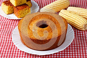 corn cake on white plate on rustic wooden table. Typical Brazilian party food