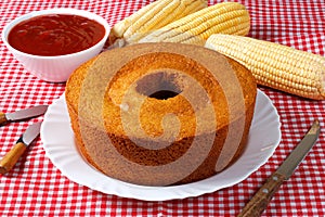 corn cake on white plate on rustic wooden table. Typical Brazilian party food