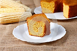 corn cake on white plate on rustic wooden table. Typical Brazilian party food