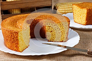 corn cake on white plate on rustic wooden table. Typical Brazilian party food