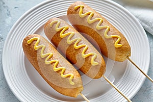 Corn dog traditional American corndog street junk food hotdog meat sausage snack with mustard