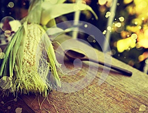 Corn ear, wooden spoon on table, food background