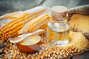 Corn essential oil bottle, corn groats, dry seeds and corncobs