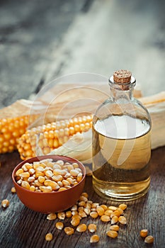 Corn essential oil bottle, seeds in bowl and two corncobs