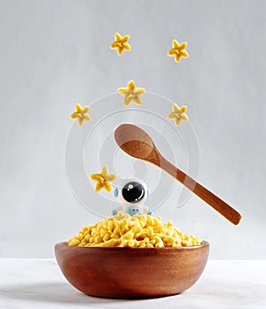 Corn flake stars bowl with little astronaut. Space day food and good morning concept