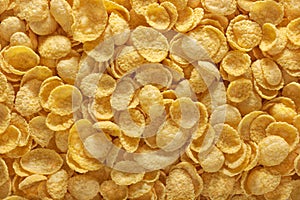 Corn flakes background. Cornflakes scattered on a table. Close up top view