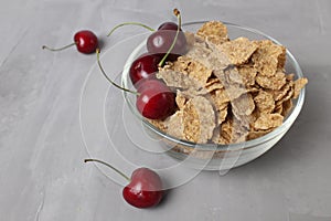 corn flakes with berries fruit cherries in a bowl plate on a gray background top view. Delicious healthy class breakfast Healthy