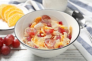 Corn flakes with berries on white wooden table. Healthy breakfast