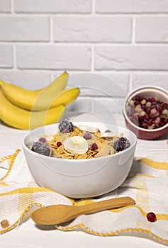 Corn Flakes Bowl with Banana, Berries and Wooden Spoon on white background, Healthy Breakfast