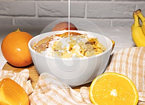Corn Flakes Bowl with Milk, Persimmon, Orange and Wooden Spoon on white background, Healthy Breakfast