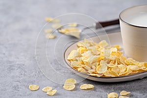 Corn flakes bowl sweeties with milk on gray cement background, close up, fresh and healthy breakbast design concept